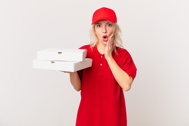 Mulher jovem e bonita se sentindo chocada e com medo. conceito de entrega de pizza