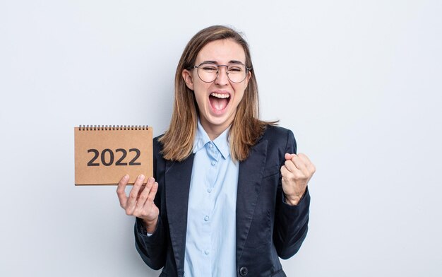 Mulher jovem e bonita se sentindo chocada, rindo e comemorando o sucesso. conceito de calendário