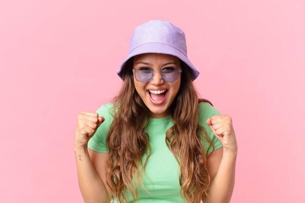 Mulher jovem e bonita se sentindo chocada, rindo e comemorando o sucesso. conceito de verão