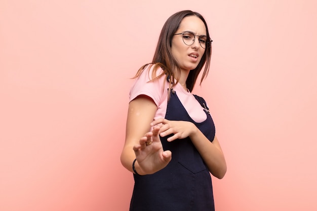 Mulher jovem e bonita se sentindo enojada e enjoada, afastando-se de algo desagradável