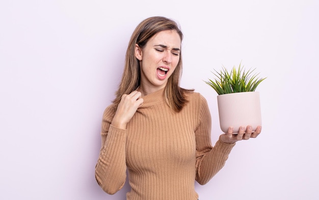 Mulher jovem e bonita se sentindo estressada, ansiosa, cansada e frustrada. conceito de planta