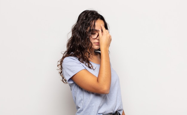 Foto mulher jovem e bonita se sentindo estressada, infeliz e frustrada, tocando a testa e sofrendo de enxaqueca de forte dor de cabeça