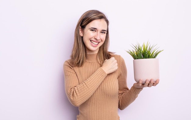 Mulher jovem e bonita se sentindo feliz e enfrentando um desafio ou comemorando. conceito de planta