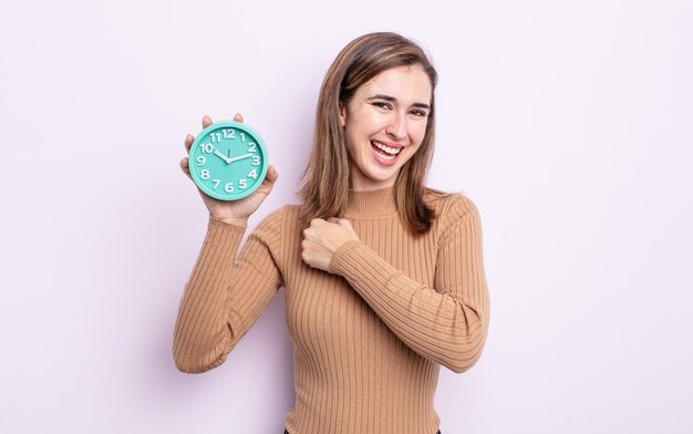 Foto mulher jovem e bonita se sentindo feliz e enfrentando um desafio ou comemorando. despertador