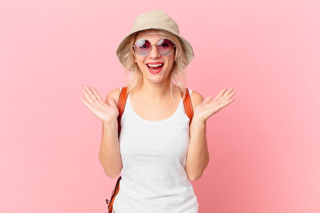 Mulher jovem e bonita se sentindo feliz e surpresa com algo inacreditável. conceito de turista de verão