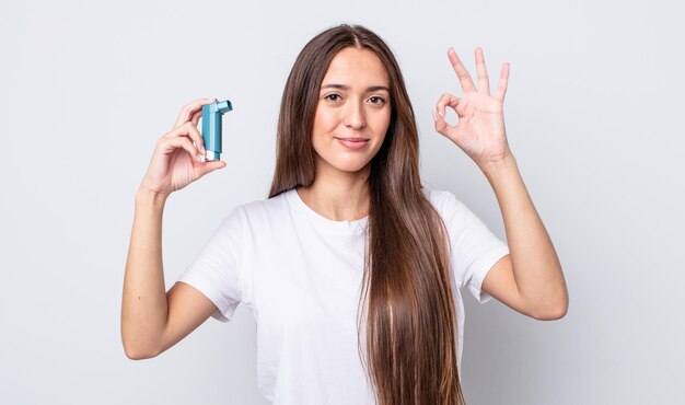 Mulher jovem e bonita se sentindo feliz, mostrando aprovação com um gesto certo. conceito de asma