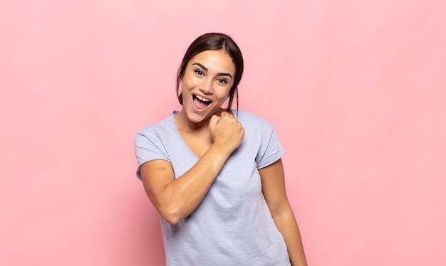 Mulher jovem e bonita se sentindo feliz, positiva e bem-sucedida, motivada para enfrentar um desafio ou comemorar bons resultados