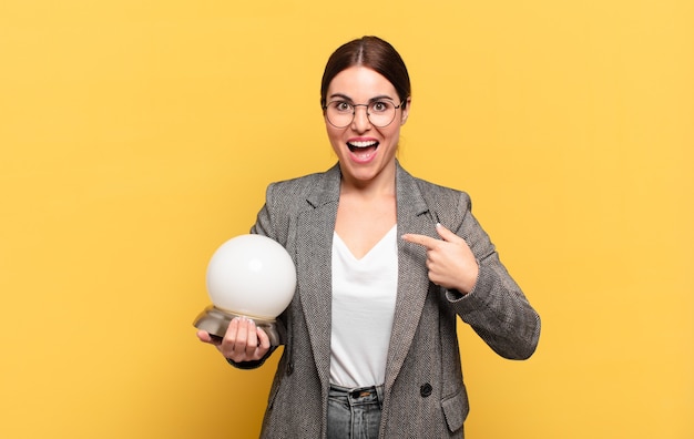 Mulher jovem e bonita se sentindo feliz, surpresa e orgulhosa, apontando para si mesma com um olhar animado e surpreso