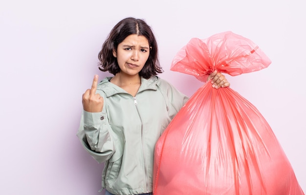 Mulher jovem e bonita se sentindo irritada, irritada, rebelde e agressiva. conceito de saco de lixo