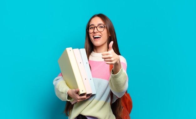 Mulher jovem e bonita se sentindo orgulhosa, despreocupada, confiante e feliz, sorrindo positivamente com o polegar para cima