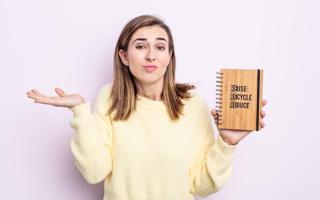 Mulher jovem e bonita se sentindo perplexa, confusa e em dúvida. conceito de reciclagem