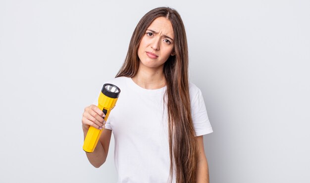 mulher jovem e bonita se sentindo perplexa e confusa. conceito de lanterna