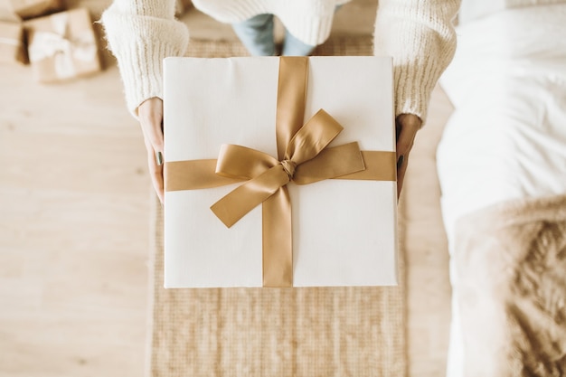 Mulher jovem e bonita segurando caixas de presente de natal com arcos