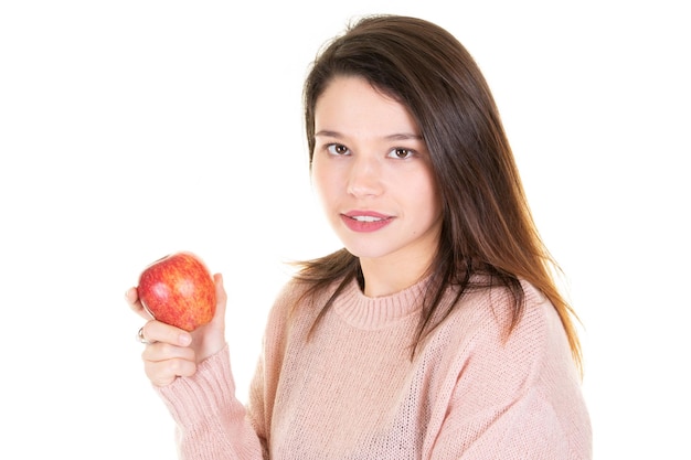 Mulher jovem e bonita segurando, mordendo uma maçã vermelha