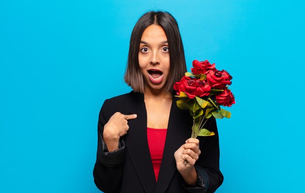 Mulher jovem e bonita segurando um buquê de rosas