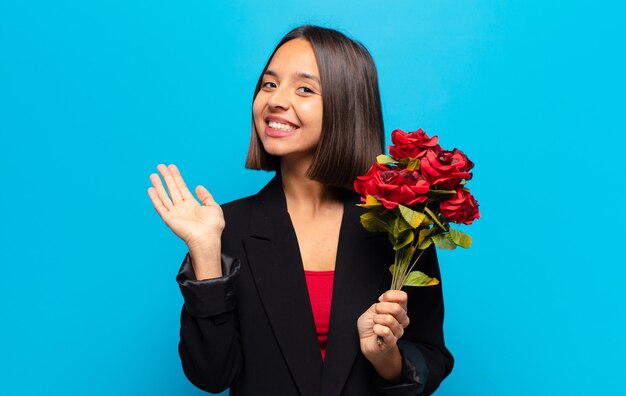 Mulher jovem e bonita segurando um buquê de rosas