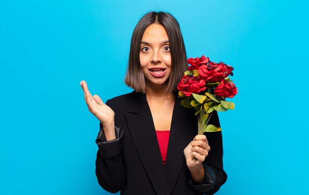 Mulher jovem e bonita segurando um buquê de rosas