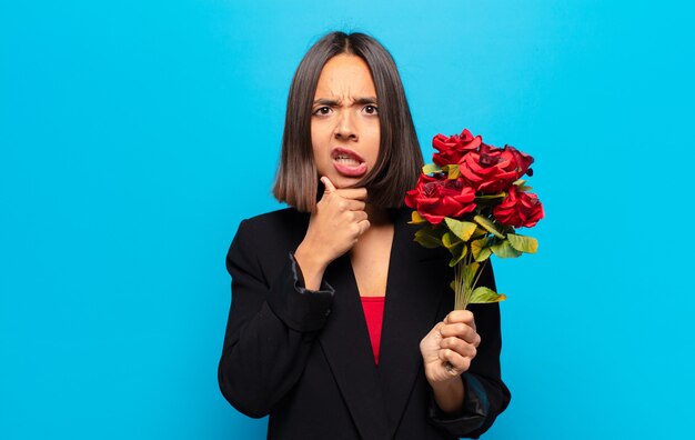 Mulher jovem e bonita segurando um buquê de rosas