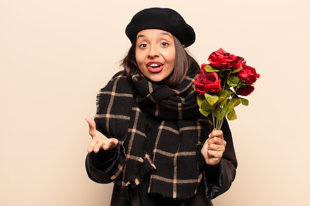 Mulher jovem e bonita segurando um buquê de rosas