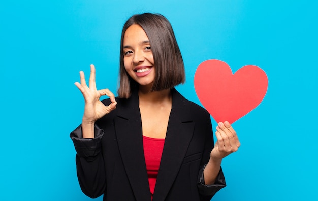 Foto mulher jovem e bonita segurando um cartão de coração