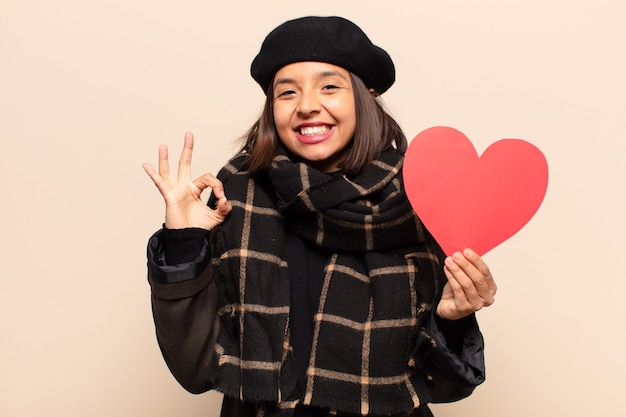 Mulher jovem e bonita segurando um cartão de coração