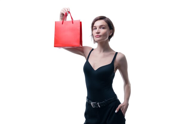 Mulher jovem e bonita segurando um pacote de artesanato vermelho na mão