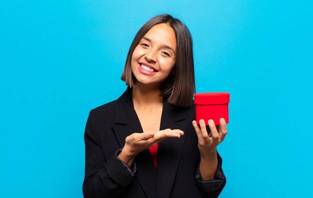 Mulher jovem e bonita segurando uma caixa de presente