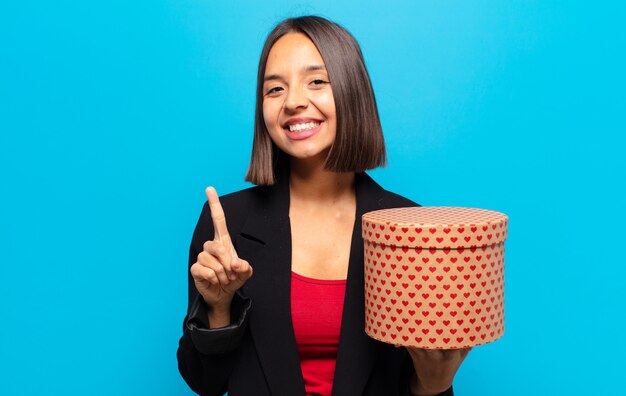 Mulher jovem e bonita segurando uma caixa de presente