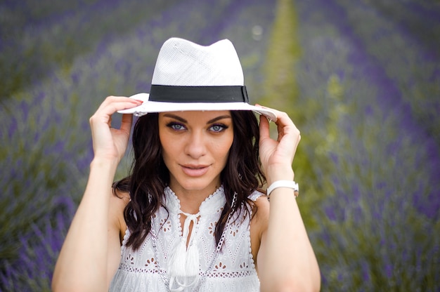 mulher jovem e bonita sensual com chapéu e vestido branco no campo de lavanda