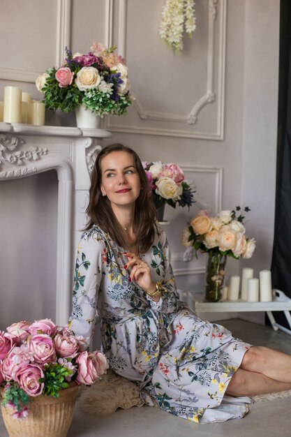 Mulher jovem e bonita sentada em uma sala entre as flores