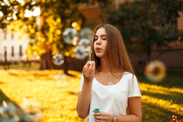 Mulher jovem e bonita soprando bolhas de sabão