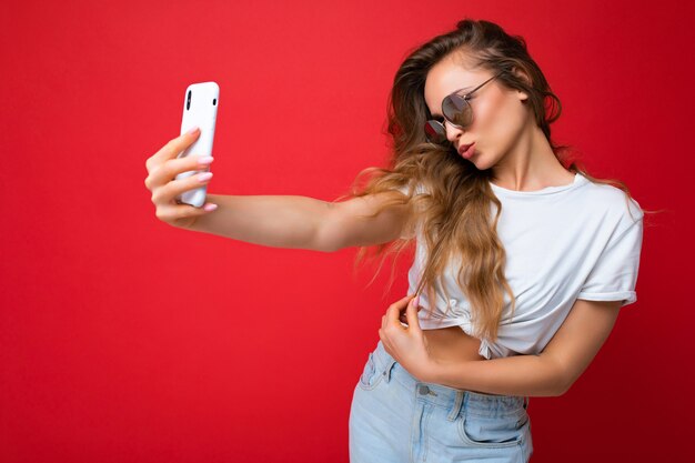 Mulher jovem e bonita sorridente com emoções sinceras isoladas