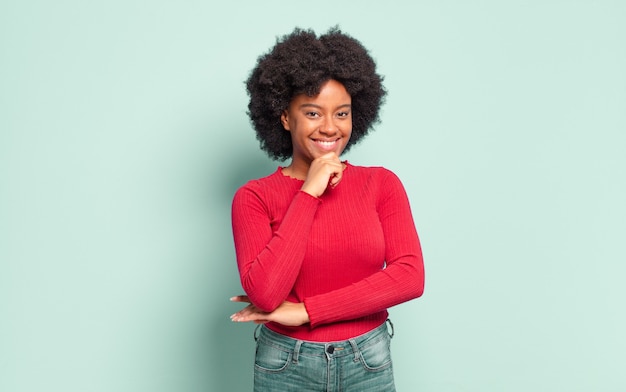 Mulher jovem e bonita sorridente posando com a mão no queixo