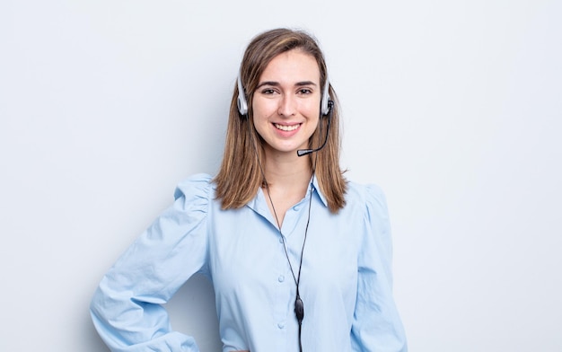 Mulher jovem e bonita sorrindo alegremente com uma mão no quadril e confiante. conceito de telemarketing