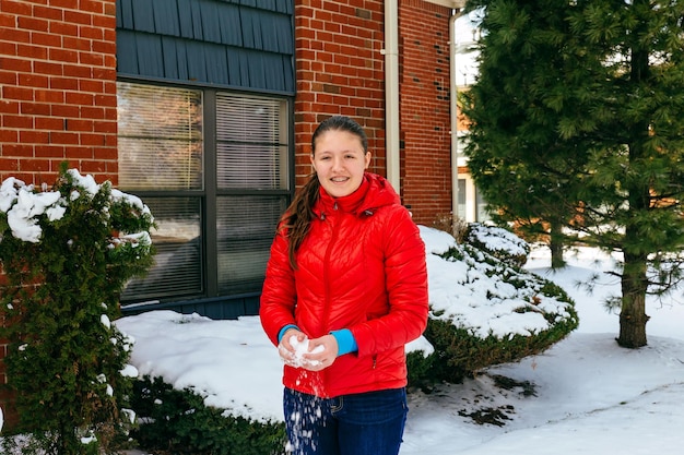 Mulher jovem e bonita sorrindo alegremente enquanto caminha pelo campo de inverno com seus patins de gelo o