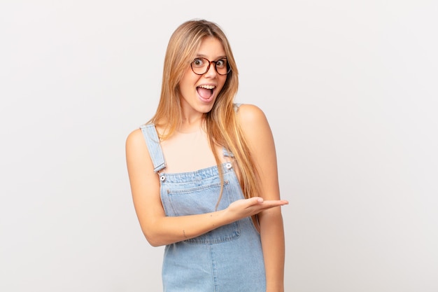 Mulher jovem e bonita sorrindo alegremente, sentindo-se feliz e mostrando um conceito