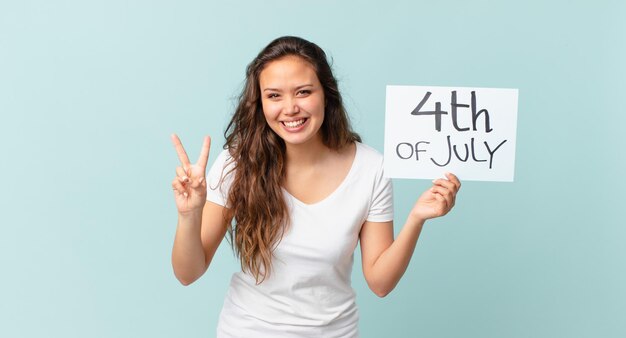 Mulher jovem e bonita sorrindo e parecendo amigável, mostrando o conceito número dois do dia da independência