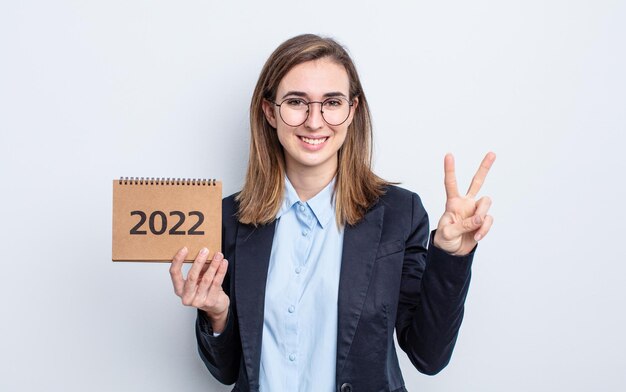 Mulher jovem e bonita sorrindo e parecendo amigável, mostrando o número dois. conceito de calendário