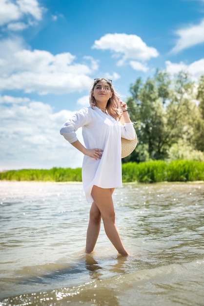 Mulher jovem e bonita sozinha caminhando na praia, aproveite a liberdade, dia de sol