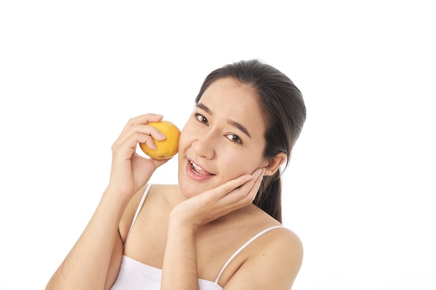 Mulher jovem e bonita spa com laranja na mão, isolada no fundo branco