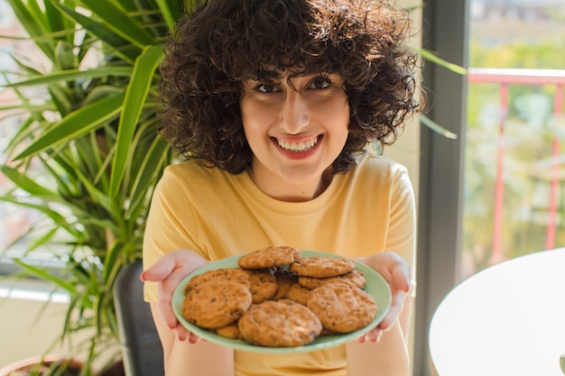 Foto mulher jovem e bonita tomando café da manhã em casa