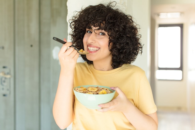 Foto mulher jovem e bonita tomando café da manhã em casa