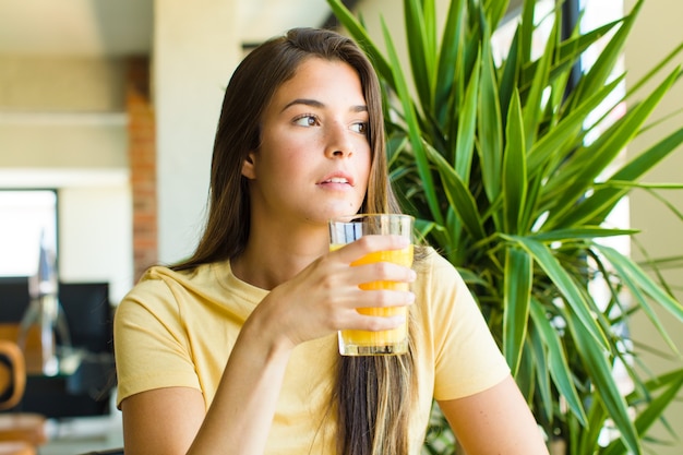 Mulher jovem e bonita tomando café da manhã em casa