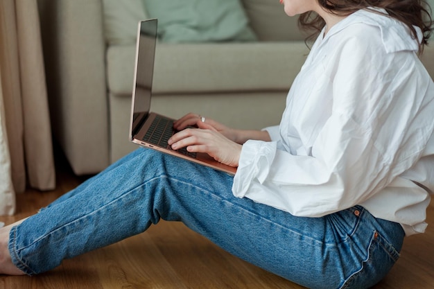 Mulher jovem e bonita trabalha online em casa com um laptop Home Office Estude online Mídia social Conversa em vídeo Casa aconchegante