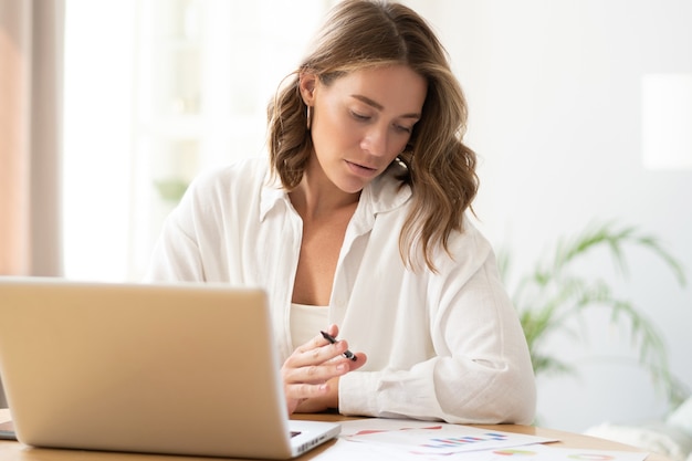 Mulher jovem e bonita trabalhando em casa no laptop.