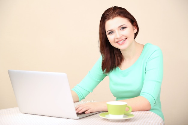 Mulher jovem e bonita trabalhando em um laptop na luz