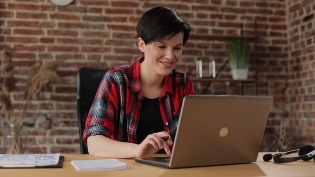 Foto mulher jovem e bonita trabalhando em um laptop