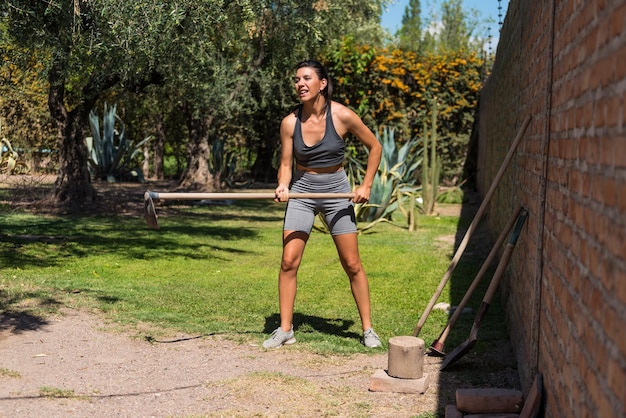 Mulher jovem e bonita trabalhando na terra mulher trabalhadora muscular magra