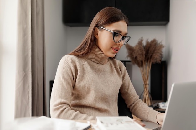 Mulher jovem e bonita trabalhando no computador portátil