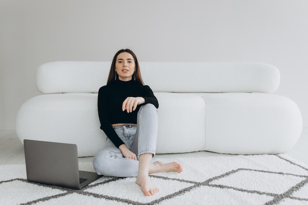 Mulher jovem e bonita usando o laptop em casa